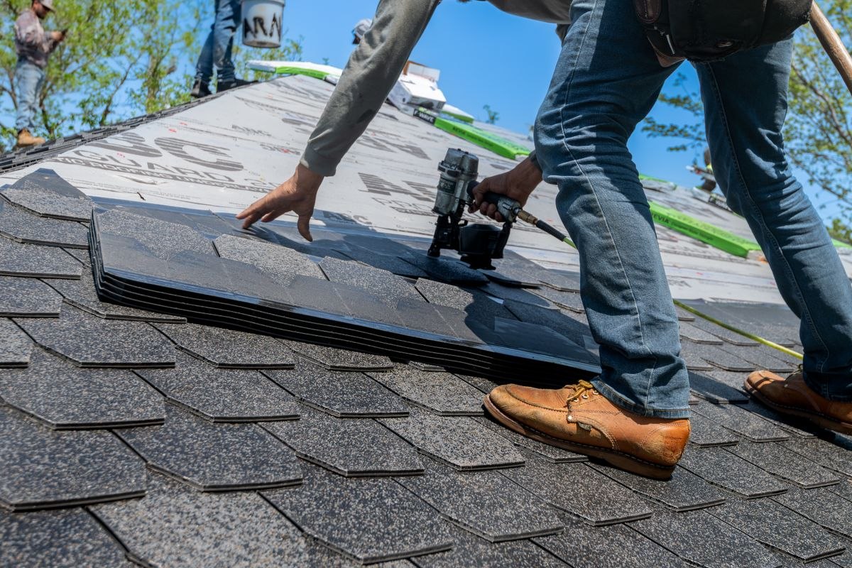 Nail gun placing new shingles