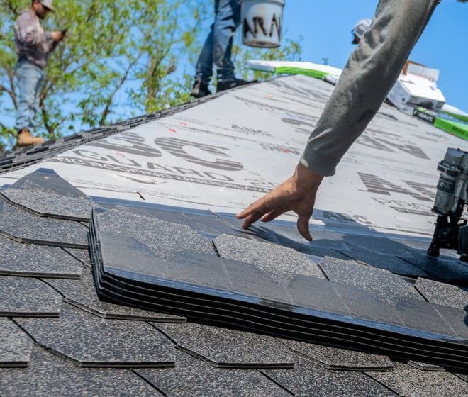Roofer placing shingles