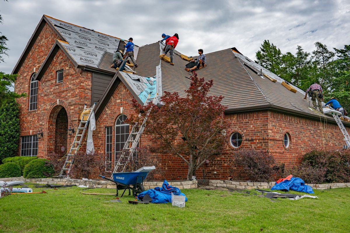 Roofing crew re-roofing a brick house